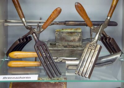 Regal mit historischem Friseur-Brennscheren aus früheren Zeiten