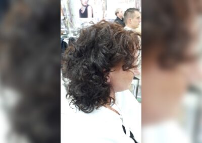 Kundin beim Friseur-Team Schöttl mit lockigem Haar im Profil